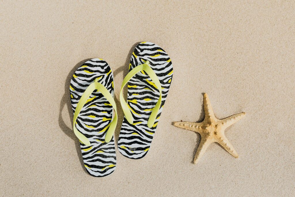 A starfish and a pair of flip-flops on the beach